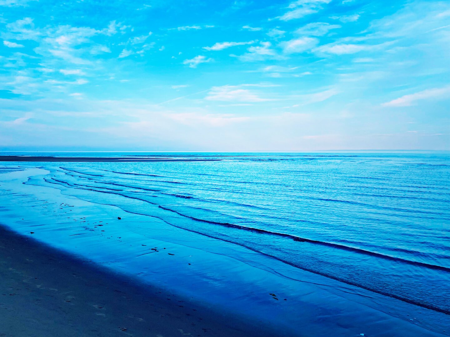 Blue ocean water with a background of cloud in the blue sky