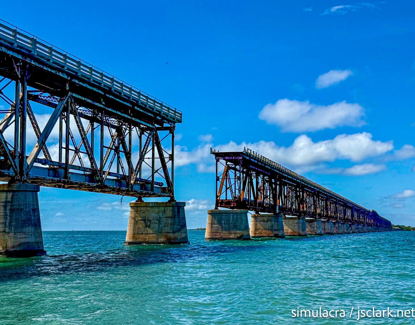 Old truss Bahia Honda bridge over green water.