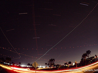 Night sky with star and airplane trails.