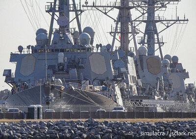Navy ships lined up in port.