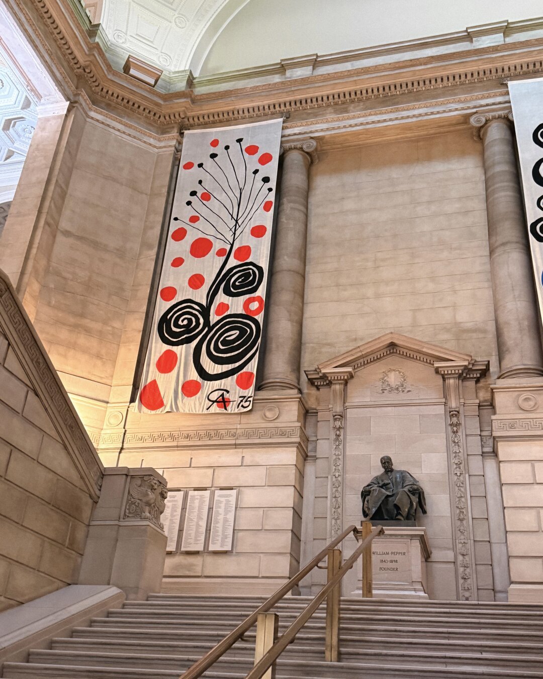A 28-foot tall banner by Alexander Calder hanging in the main branch of the Free Library of Philadelphia featuring the shapes and color characteristic of Calder’s art.