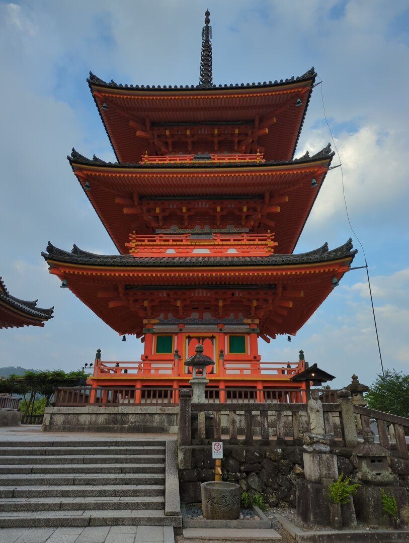 3 story, orange pagoda inside Kyomizudera in Kyoto Japan.