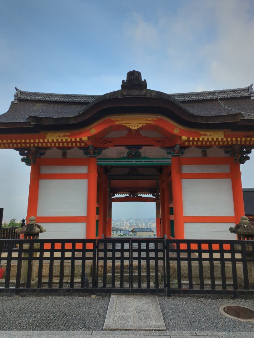 Western gate of Kyomizudera in Kyoto, viewed from inside the temple grounds. Looking through the gate, the city of Kyoto can be seen.