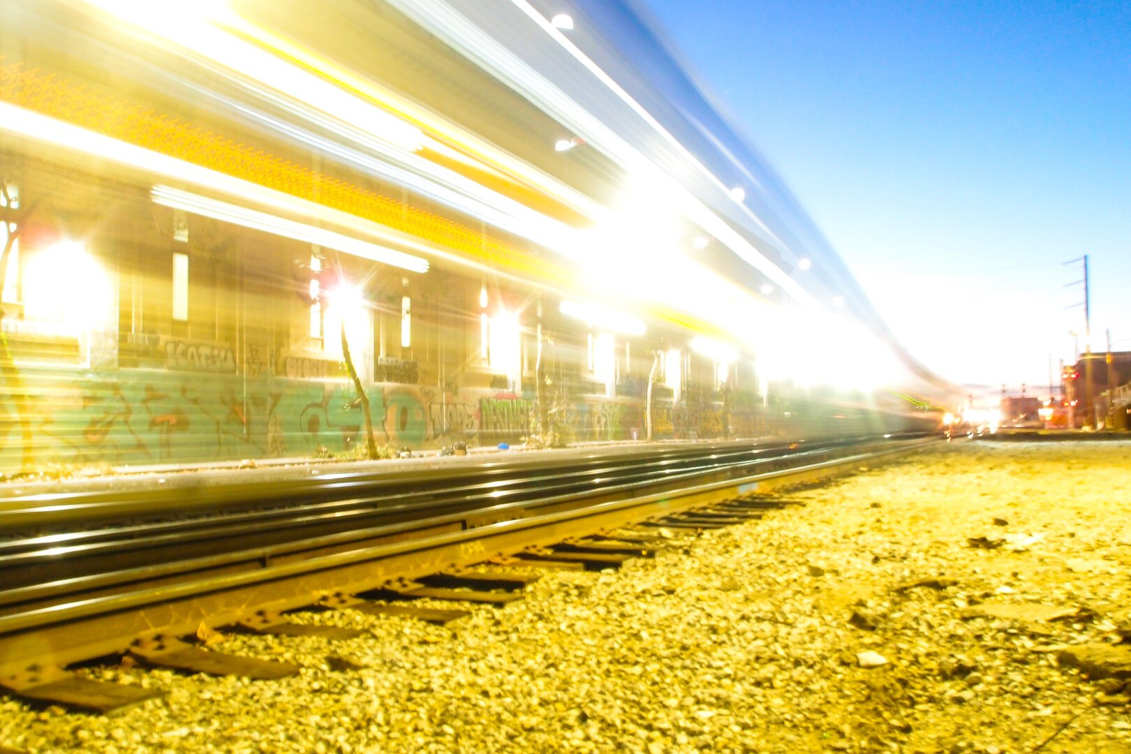 Train lights fly by at dusk.