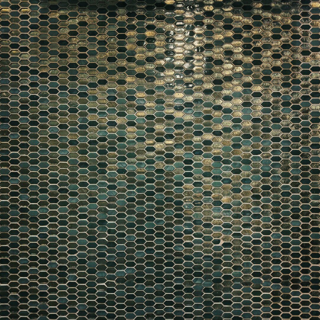 A wall fills with small emerald and gold hexagonal tiles.