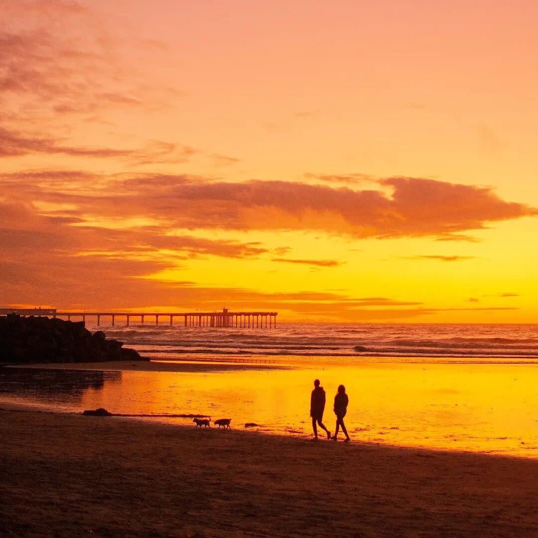 Couple walking on the beach at sunset