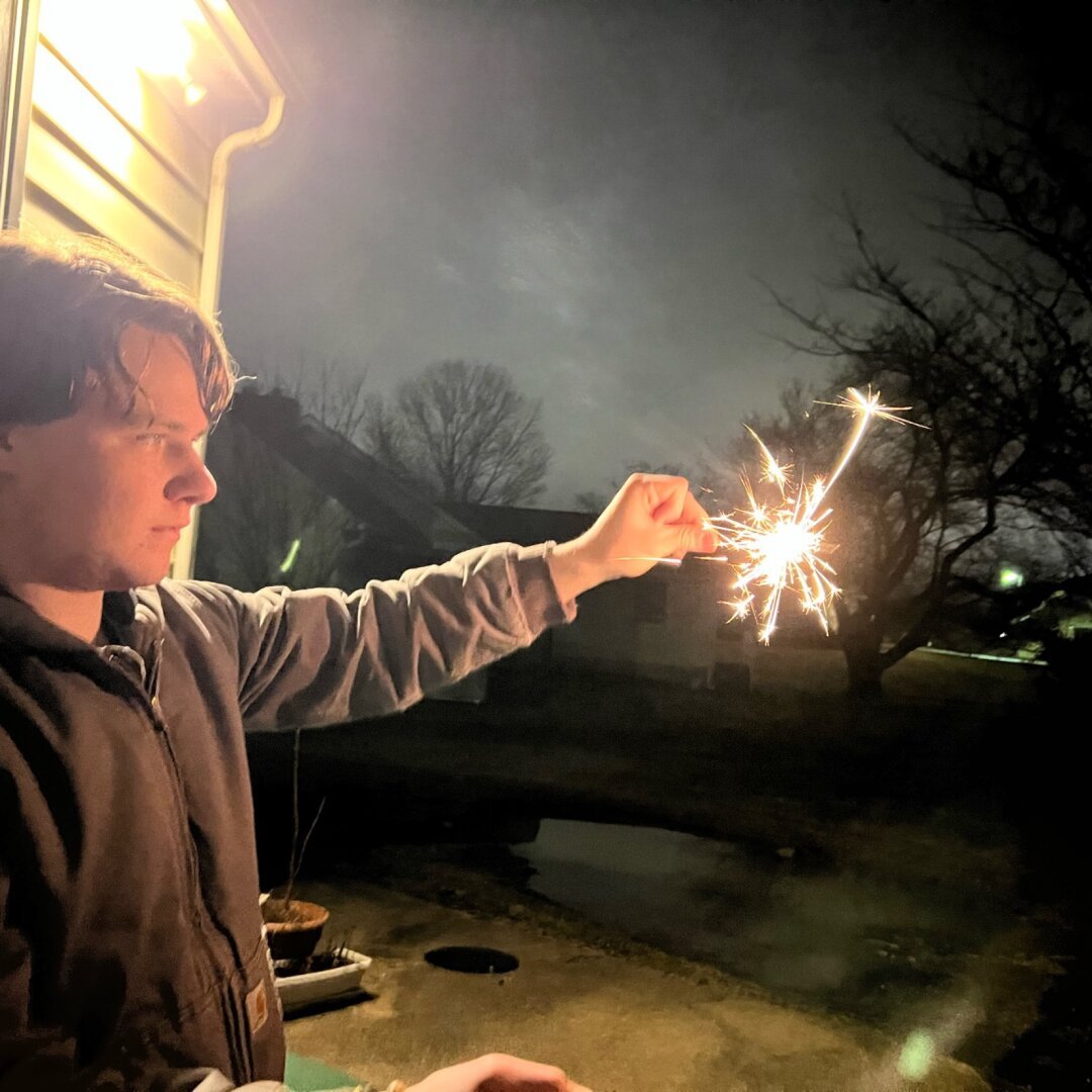 Theo holding sparkler at arm’s length.