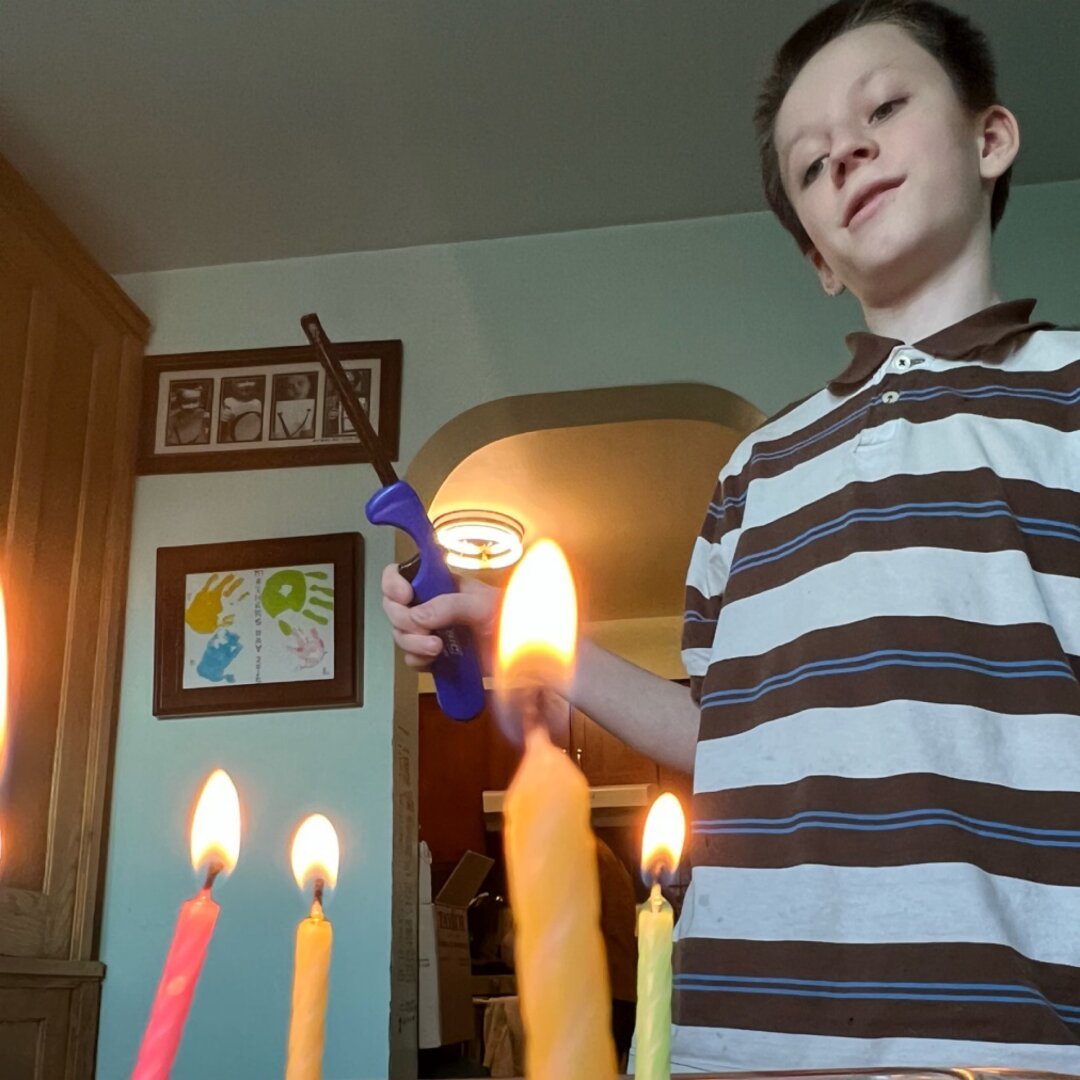 Greory lighting candles on cake.