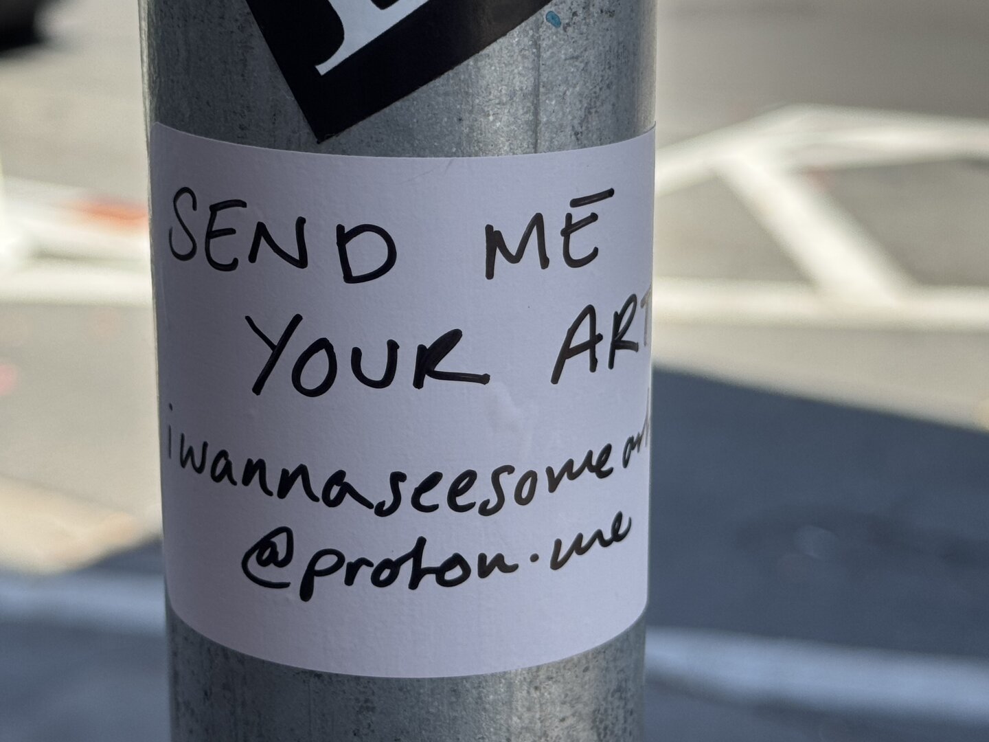 Another handwritten sticker that says "Send me your art: iwannaseesomeart@proton.me"