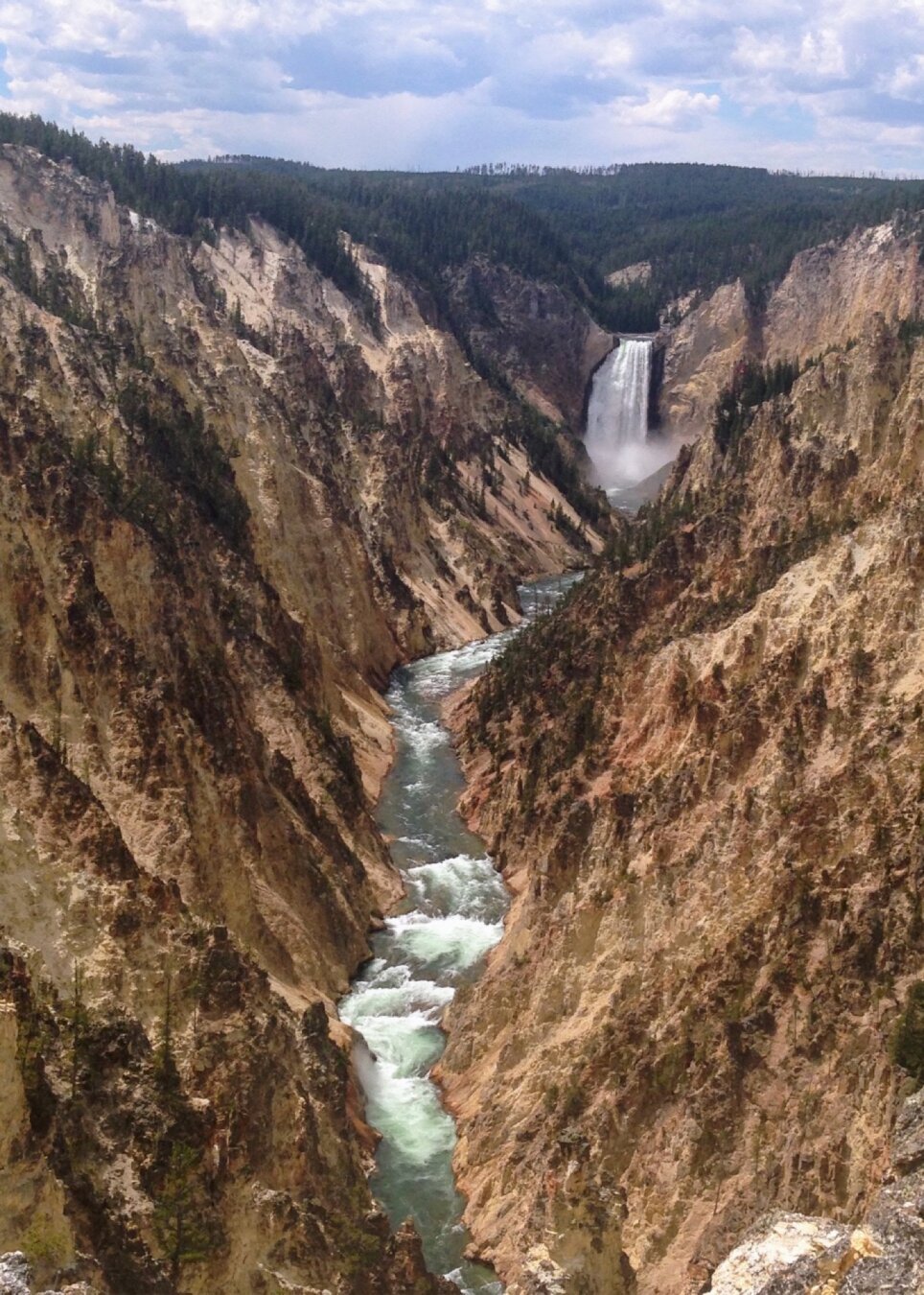 View from Artist Point overlook up the Grand Canyon of the Yellowstone. In the distance, a waterfall flows into the canyon.