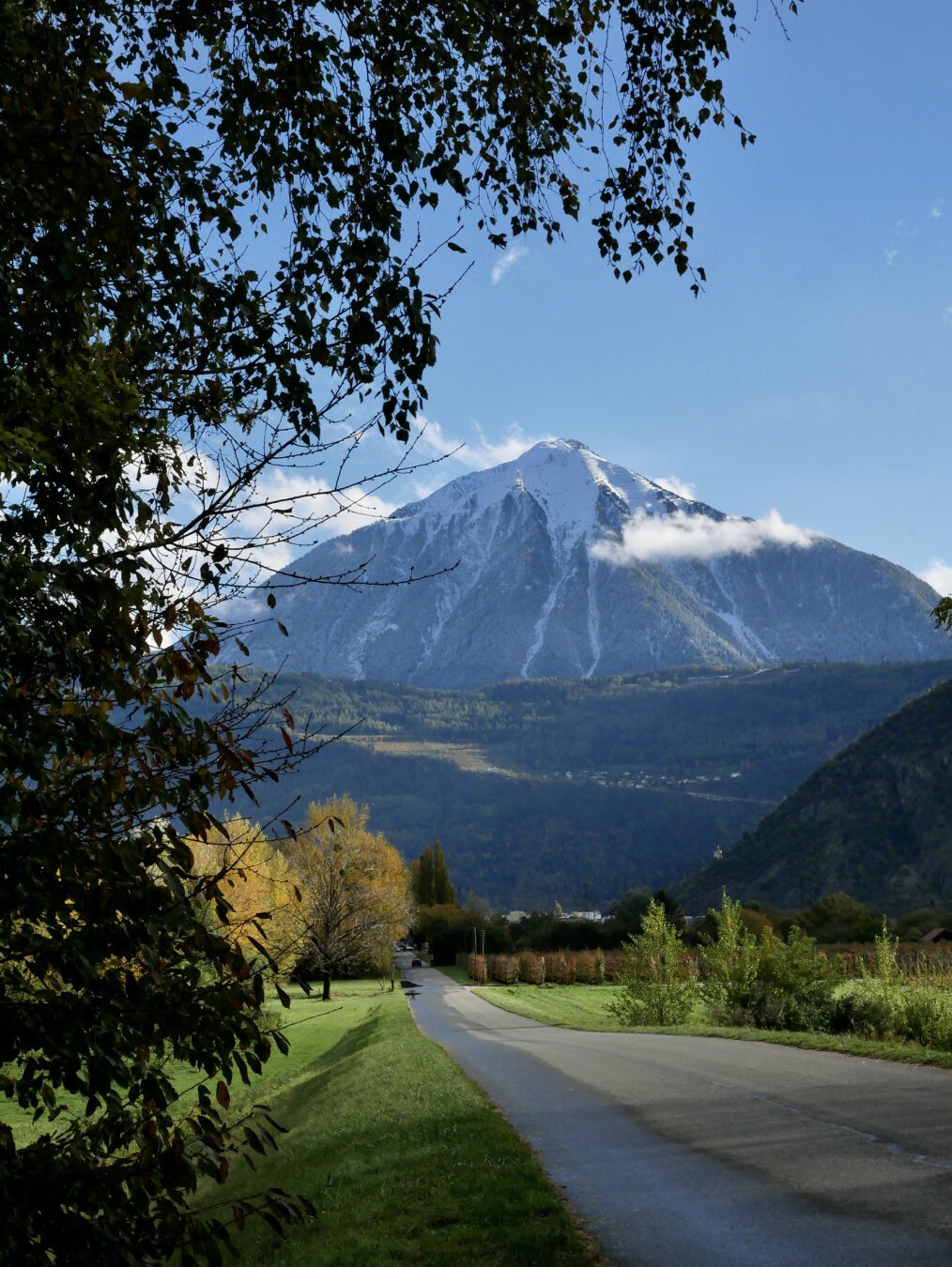 Route de campagne avec une montagne enneigée en arrière plan.