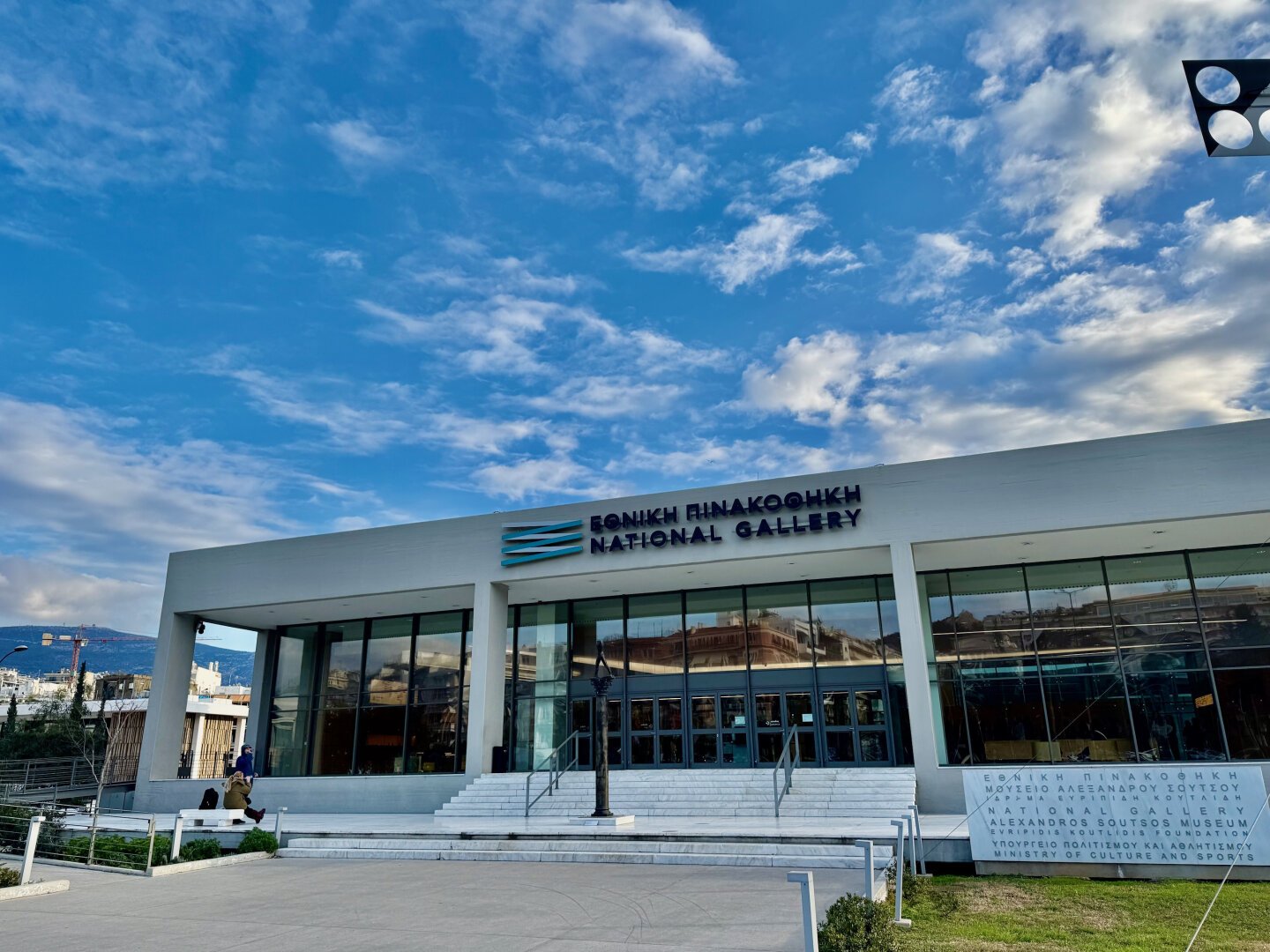 Exterior shot of the large squat white modern gallery, blue skies above