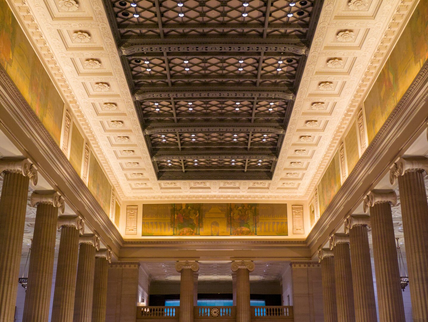 Wrought iron ceiling in the neoclassical grand lobby, surrounded by the yellow mosaic and Ionic columns below.