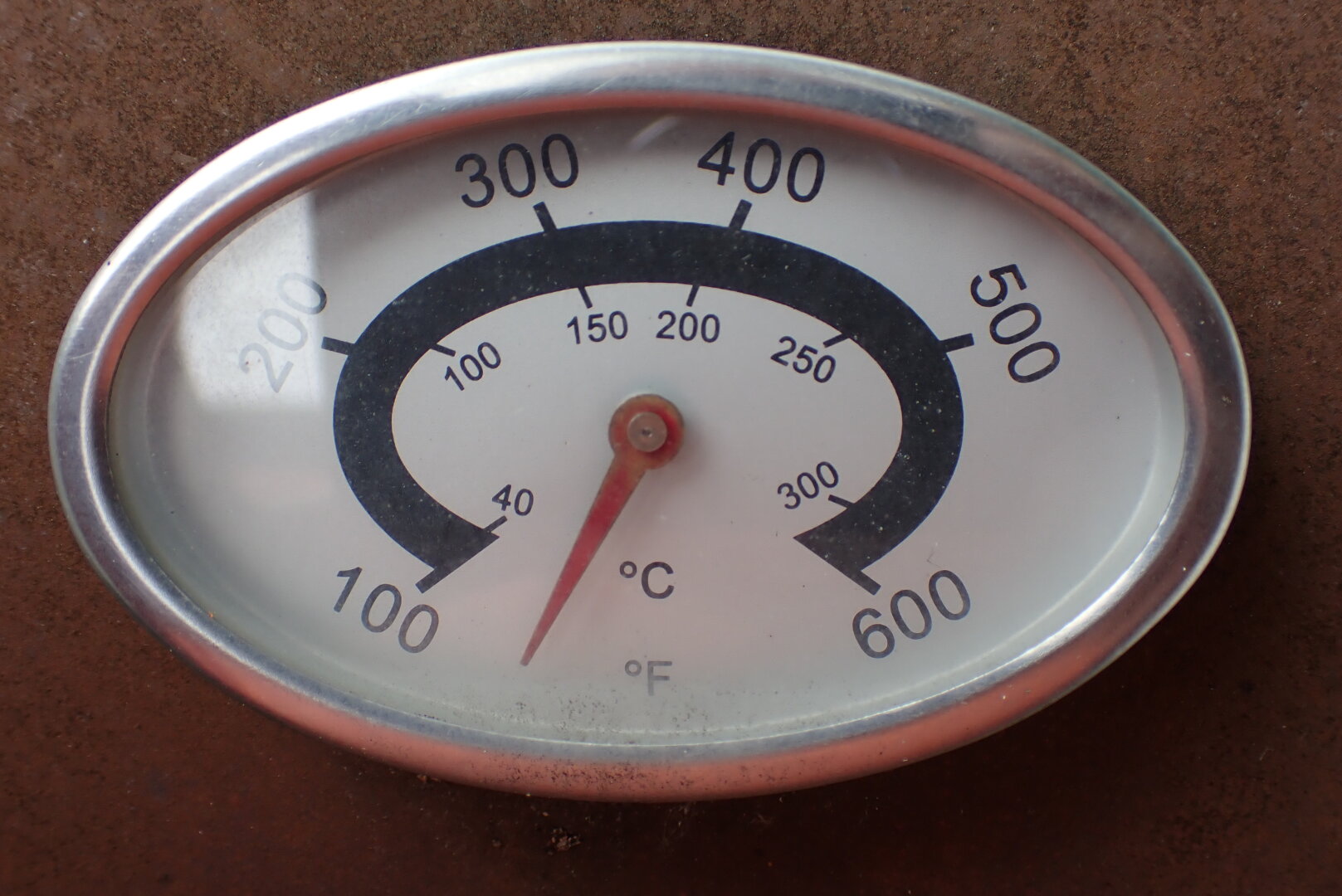 A thermostat on a rusty grill