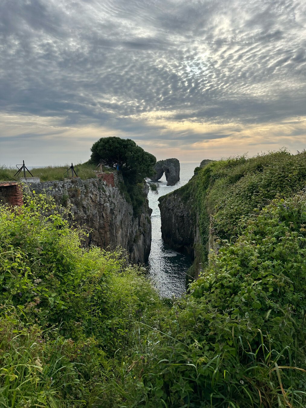 Pequeño entrante de mar con roca en forma de arco al fondo
