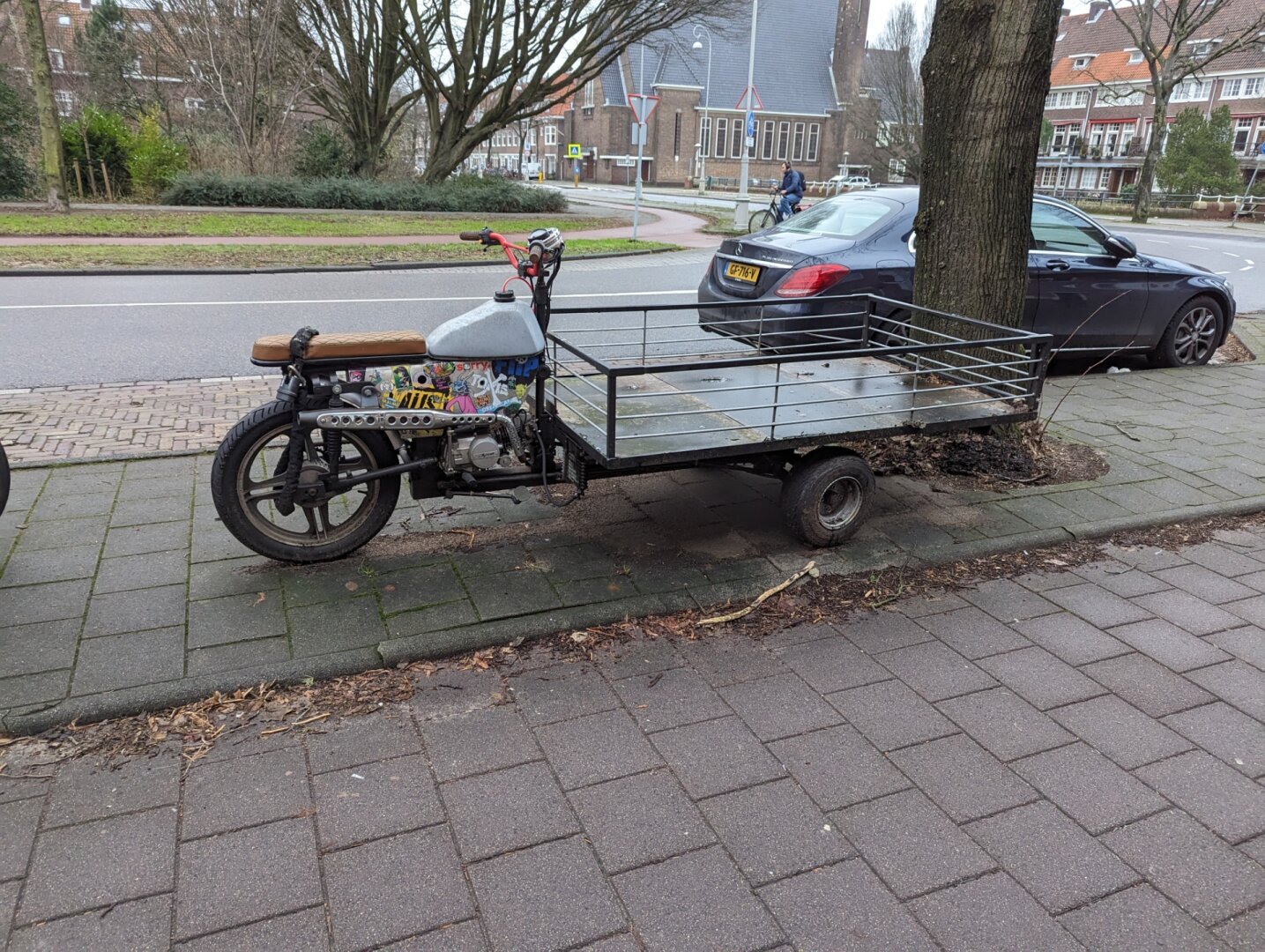 a motorcycle welded to the back of some kind of cart.