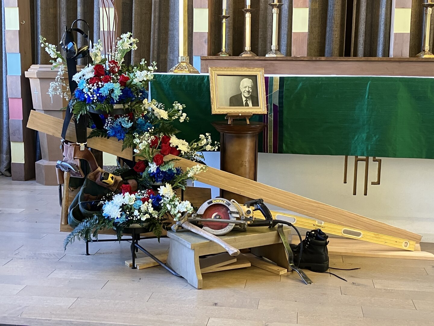 Floral display in memory of former President Jimmy Carter at St. Mark’s Episcopal Church in Albuquerque, NM on Sunday, January 19, 2025. The display included an array of flowers, a black and white photo of Carter, along with construction materials and tools.