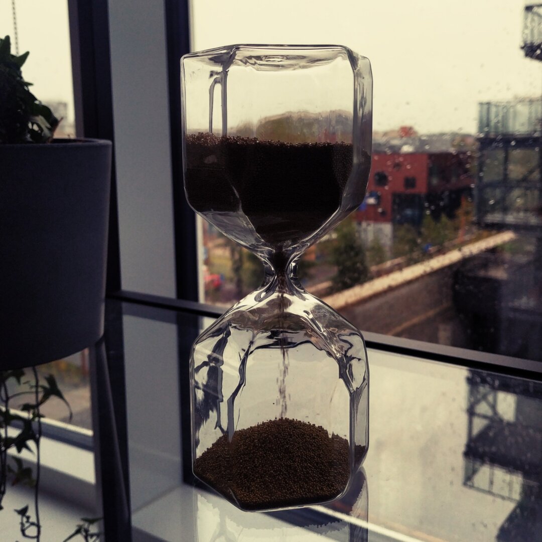 Hourglass in front of a window.