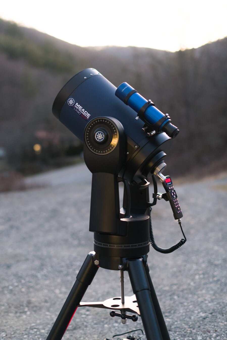 Meade LX90 telescope in a gravel driveway.