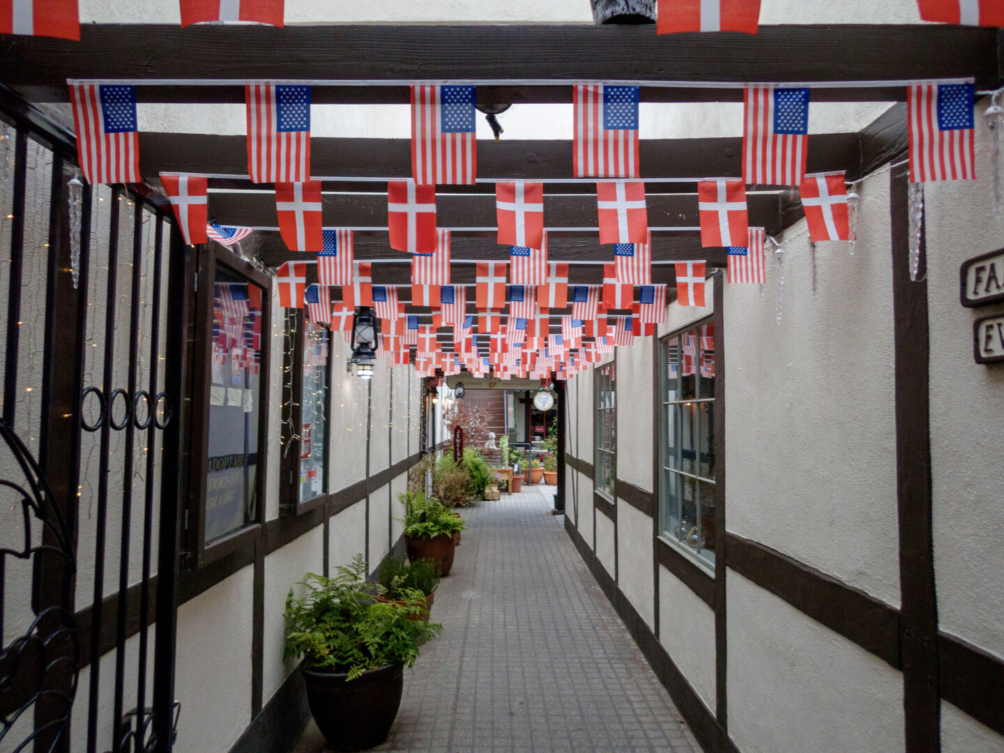 Alleyway in Solvang with Danish and American flags hanging from the rafters