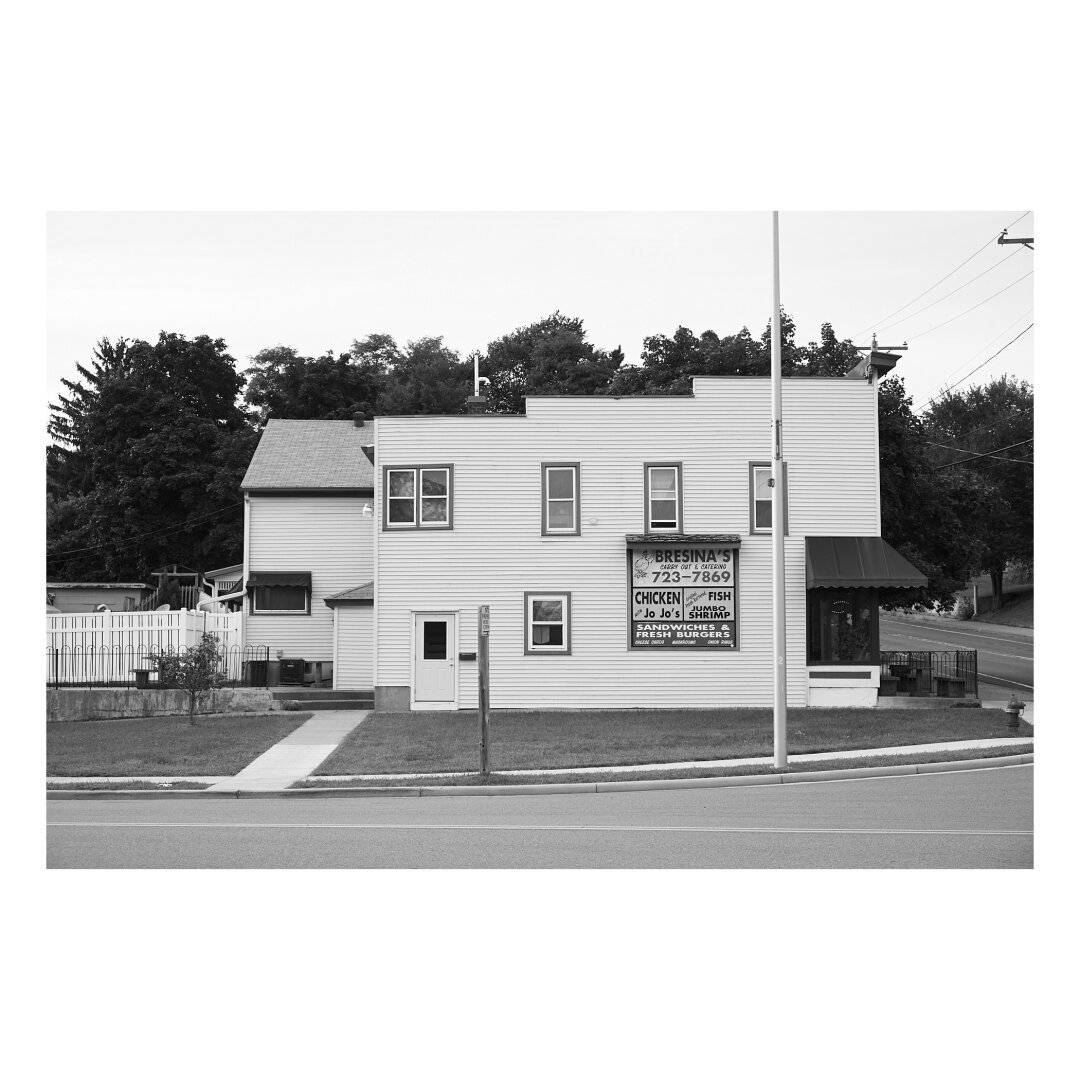 building side elevation of a midwest pizza restaurant in a leafy residential neighborhood