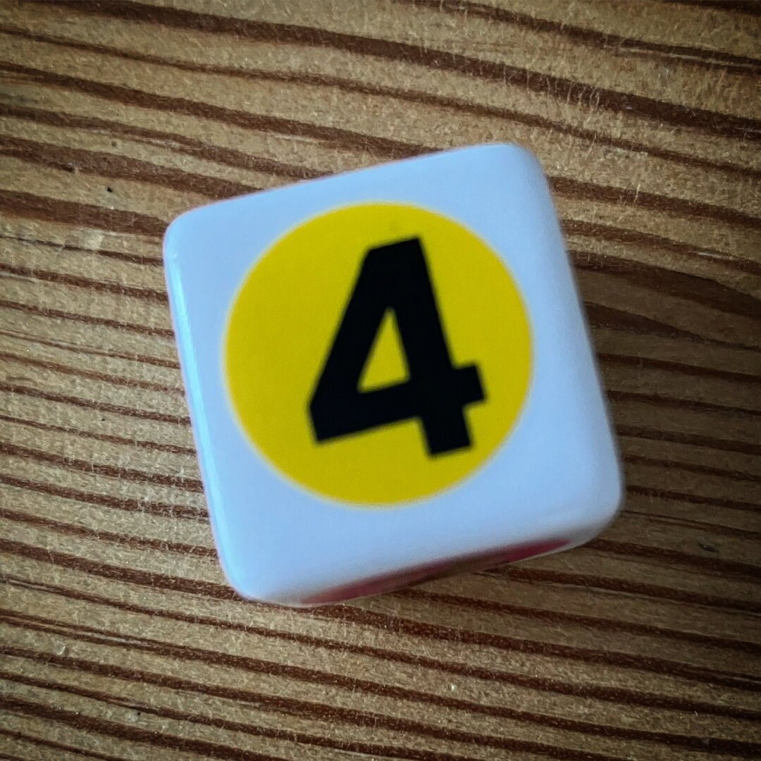 Picture of a child’s dice on a wooden surface.