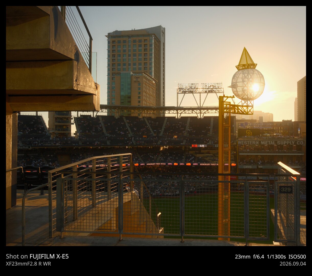 The right field foul pole at Petco Park is adorned with a giant Jack in the Box head, a la the fast food chain. The sun sets behind it, casting shadows throughout the scene.