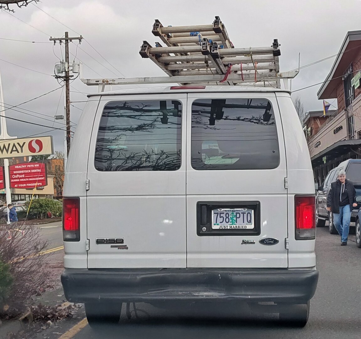 work van with ladders on the roof, and a "just married" license plate frame