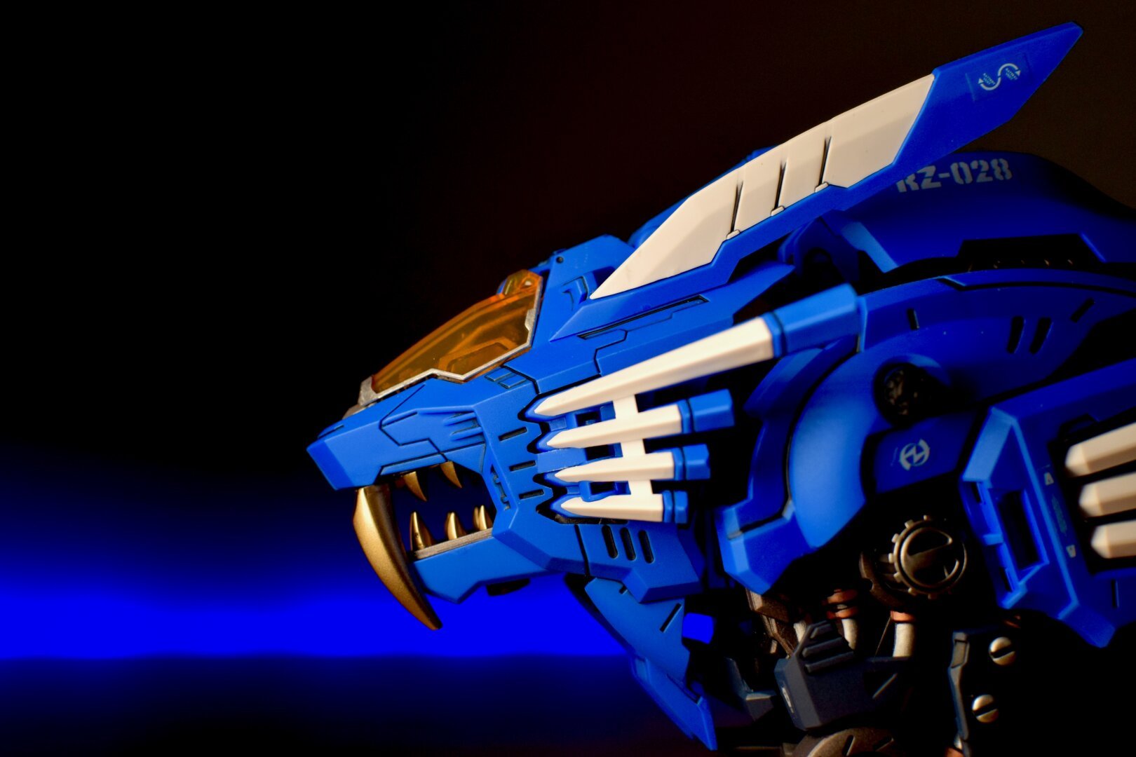 Close-up of a blue toy robot lion against a black background with blue lighting.