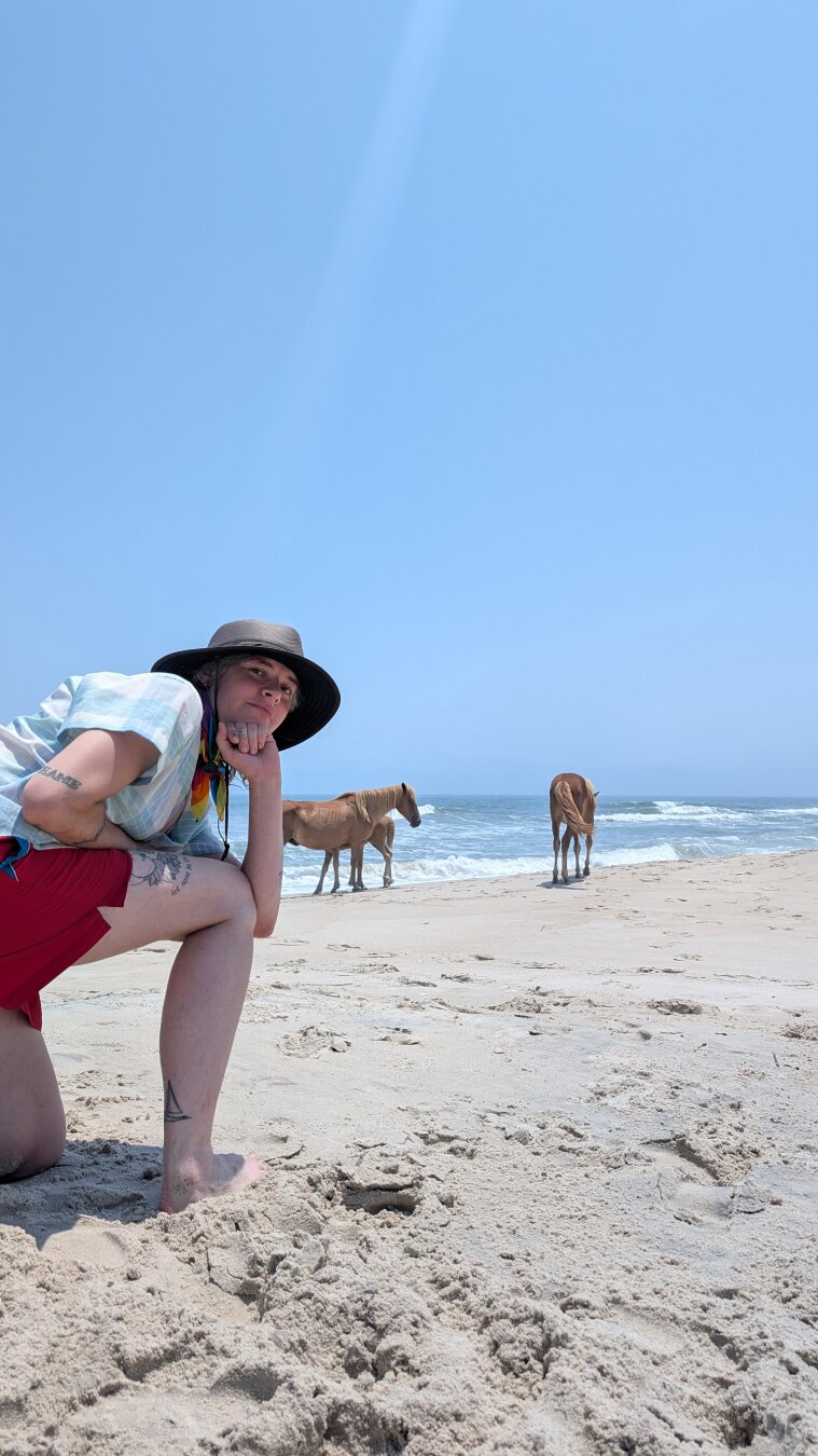 A person posing in front of a pony showing their butt to the camera.