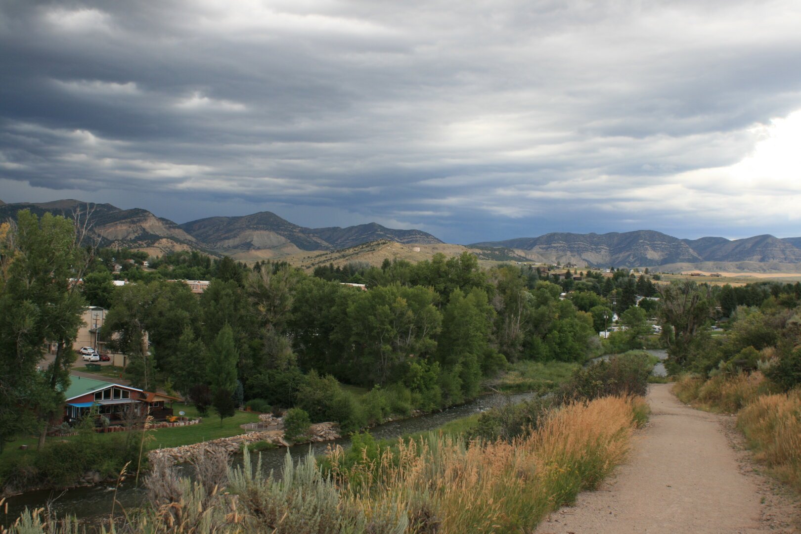 A view of the town of Meeker, Colorado, with hills in the background and a cloudy sky