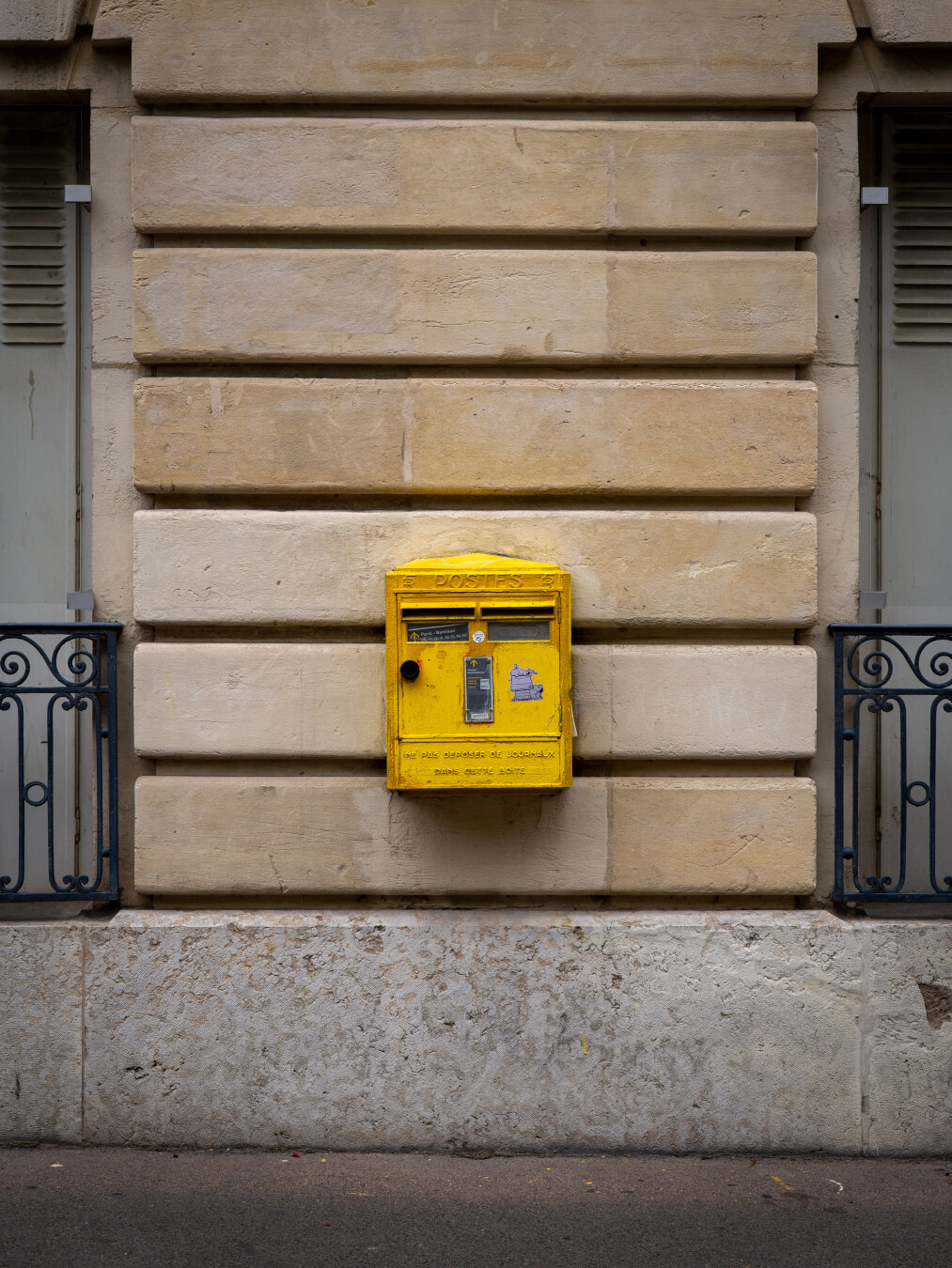 A yellow post-box on a wall.