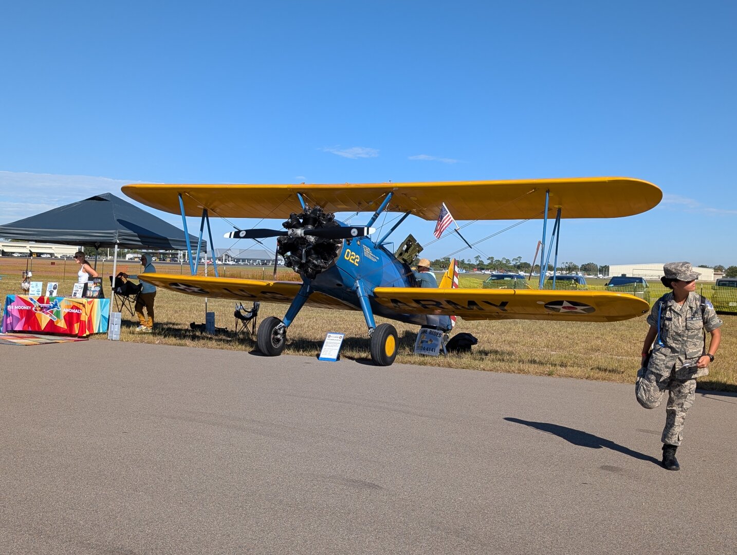 A Stearman PT-17 biplane. The plane has a blue and yellow US Army livery.