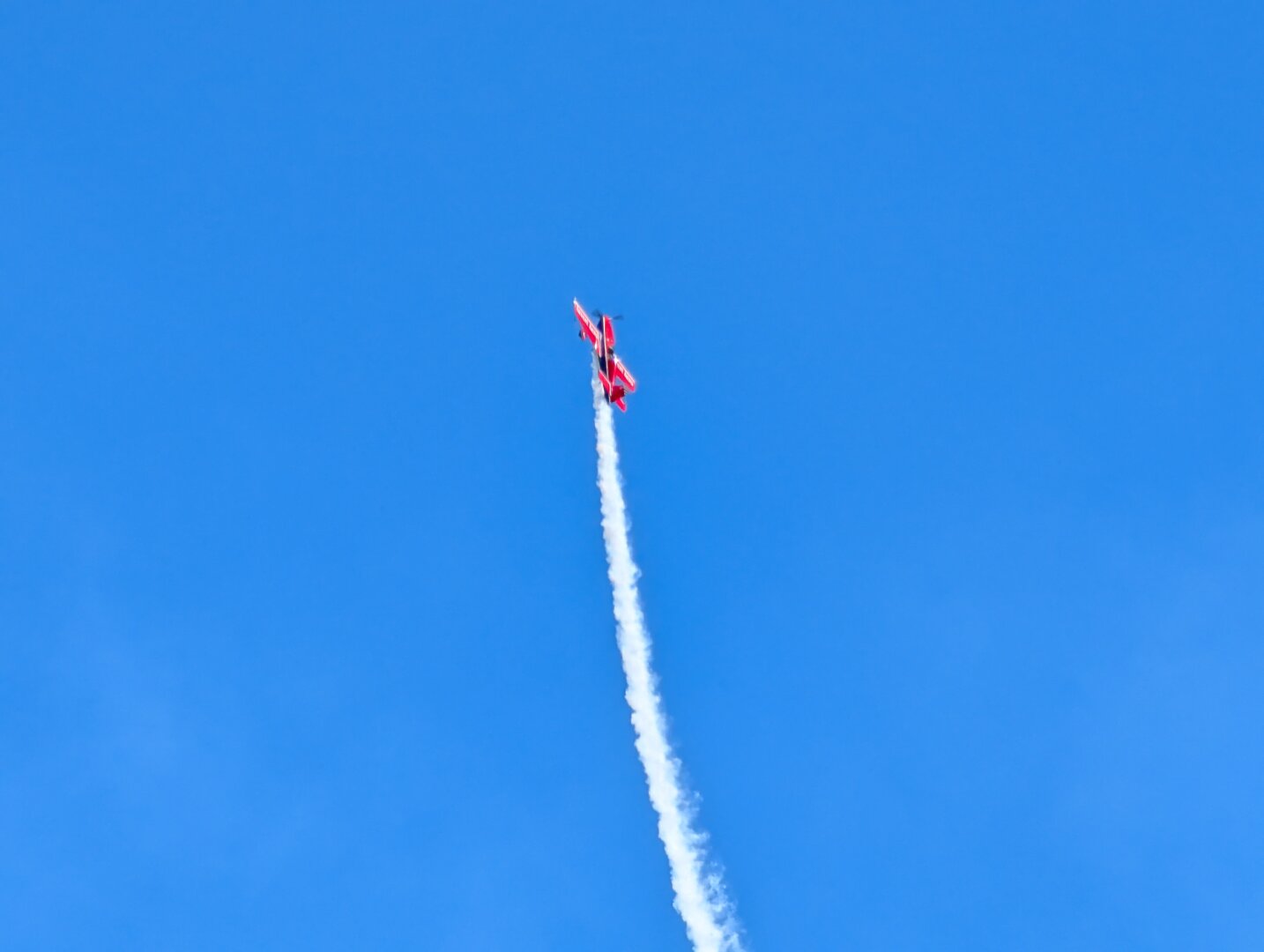An Extra 300S airplane flying straight up.  The pilot is Doug Litton.