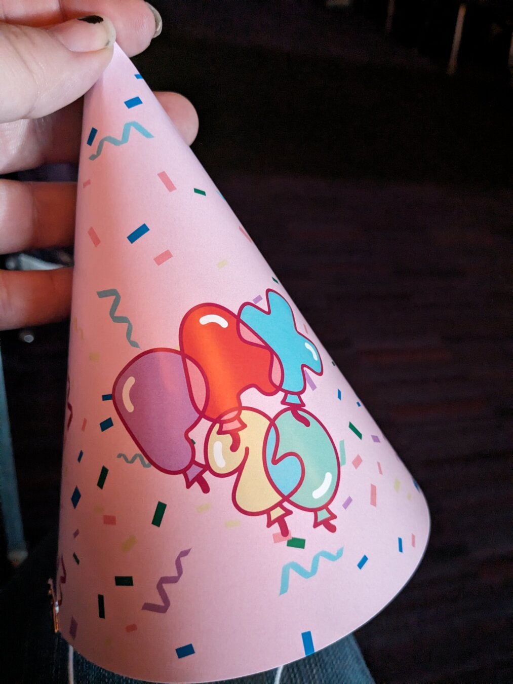 Pink party hat with balloon text reading PAX 20.