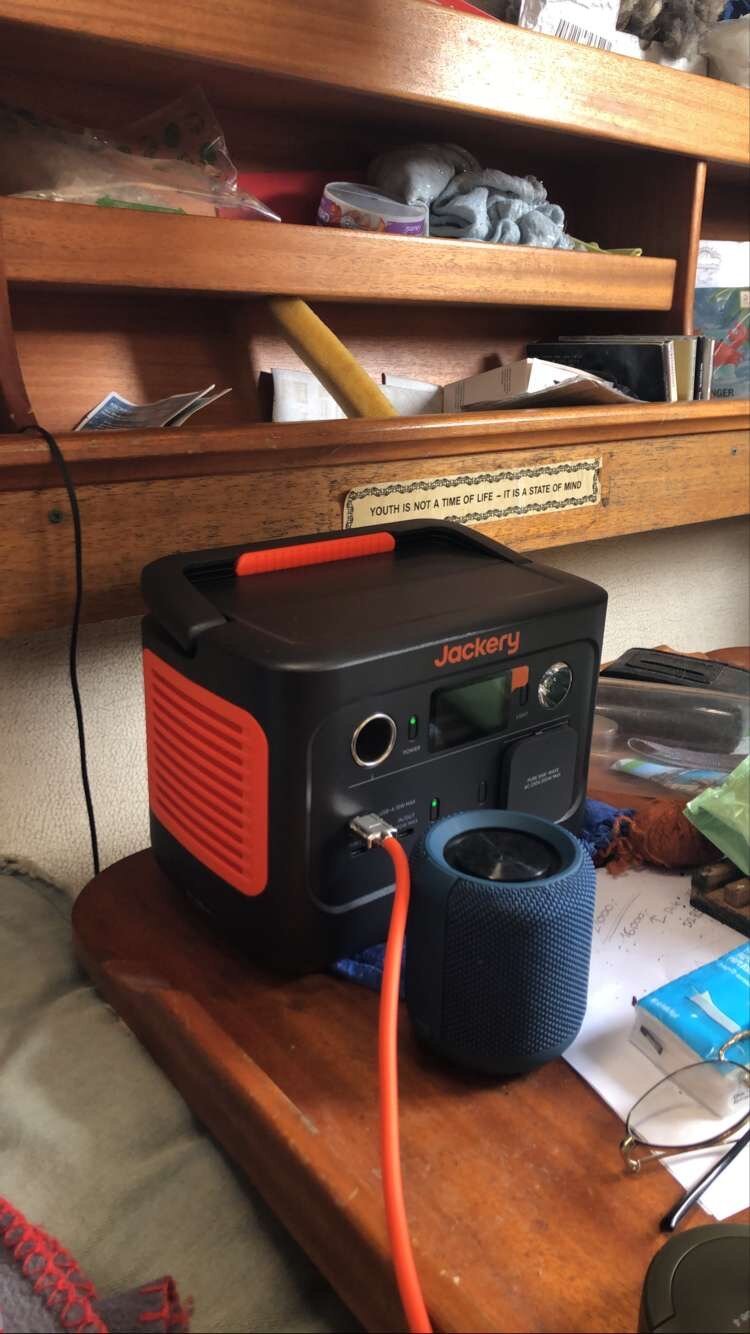 The salon table in my boat, with a power station standing on the table. There’s a sticker on the shelf behind it with saying “youth is not a time of life, it’s a state of mind”.