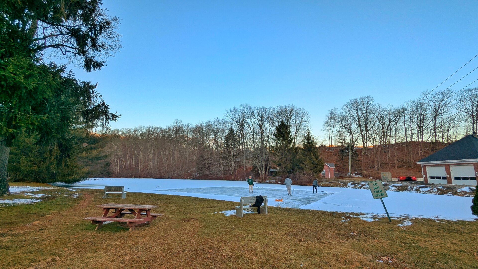 A group of boys skating on a frozen pond.