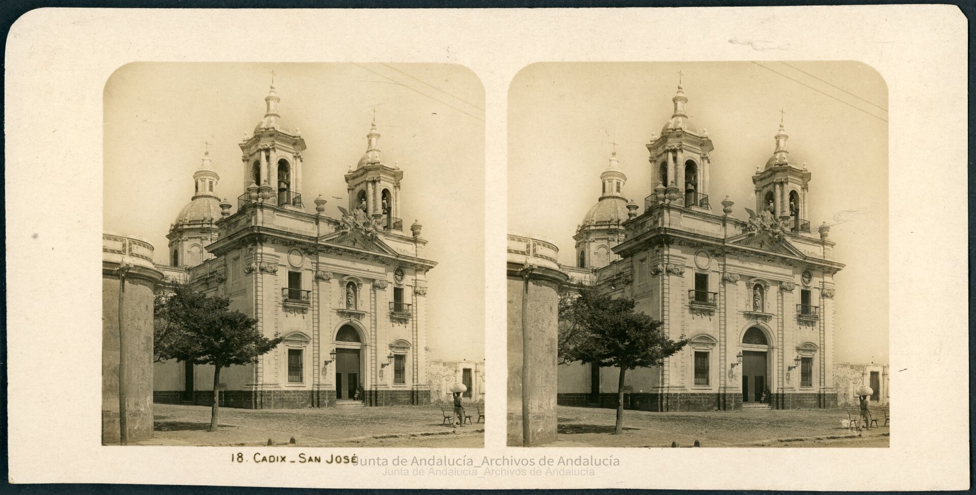 Iglesia sin grandes edificios alrededor. Tiene un muro adosado con una puerta. Enfrente tiene dos bancos.