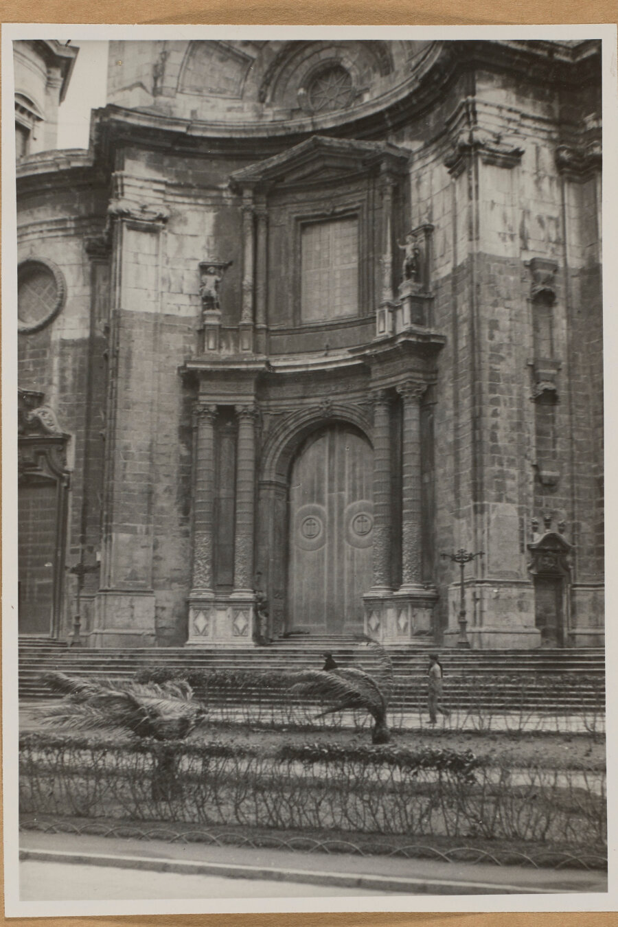 Puerta central de la catedral con un jardín delante.