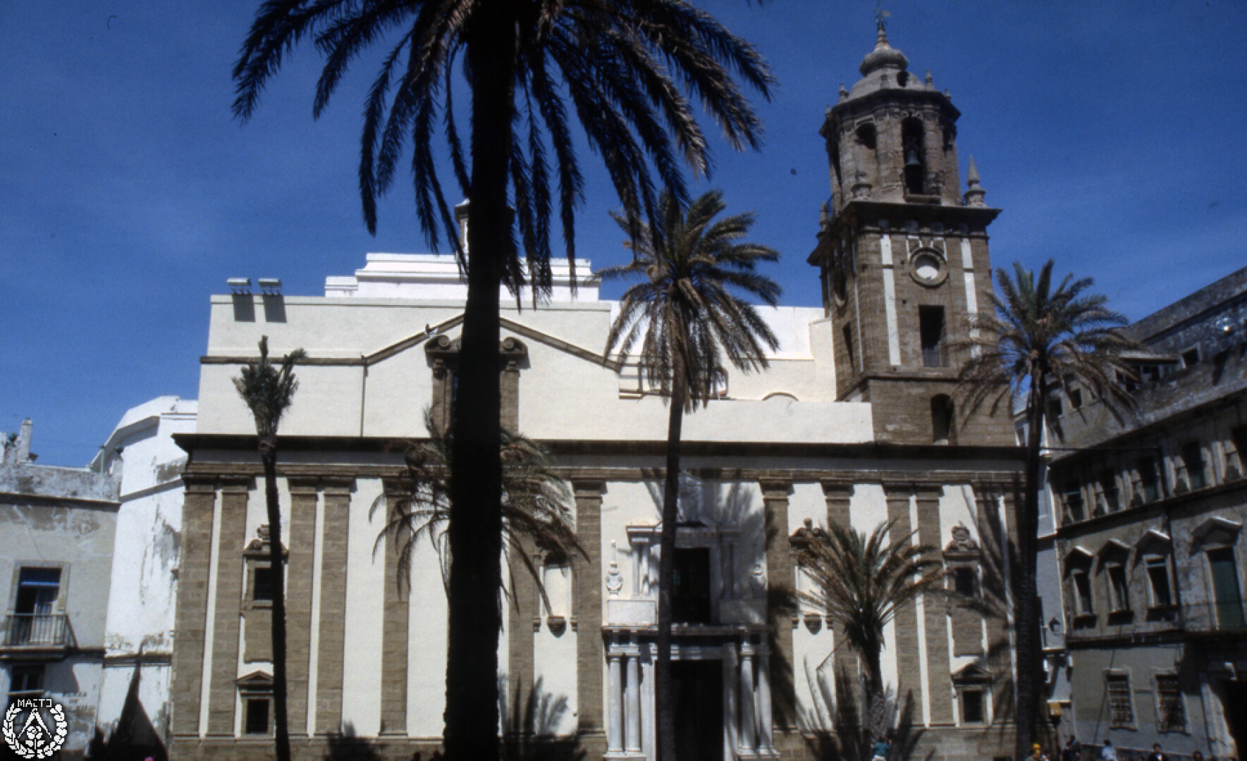 Iglesia en una plaza con campanario en la esquina de la calle.