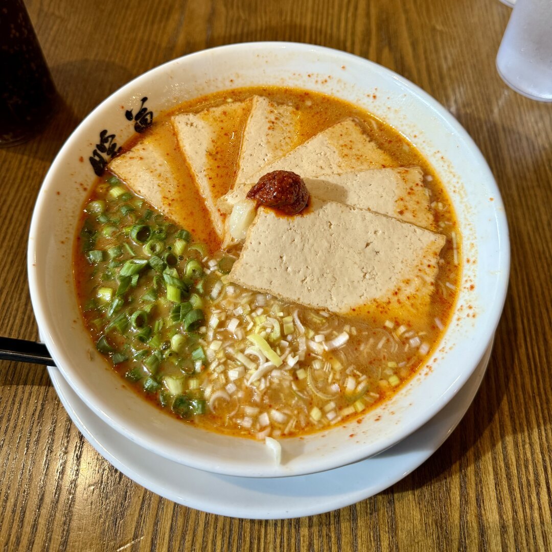 A large bowl of vegan miso ramen with tofu.