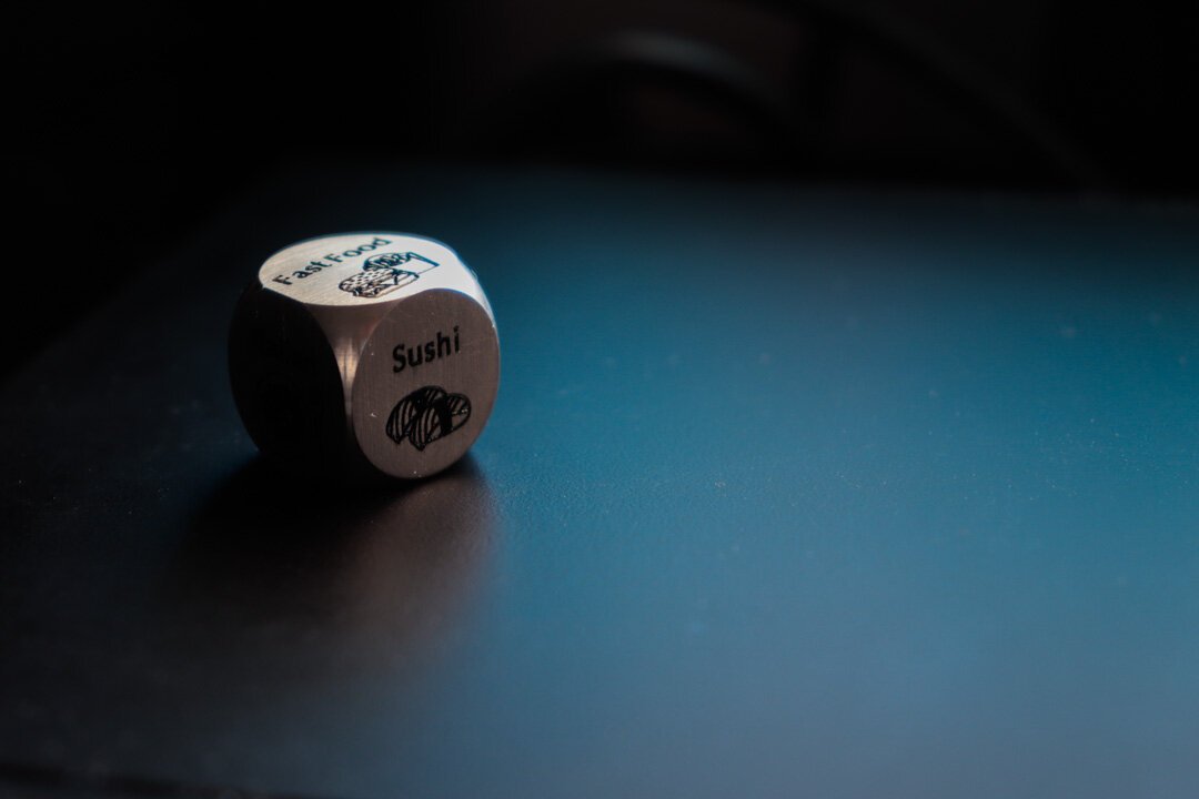 A metallic die with different foods on each face to help you decide what to eat.