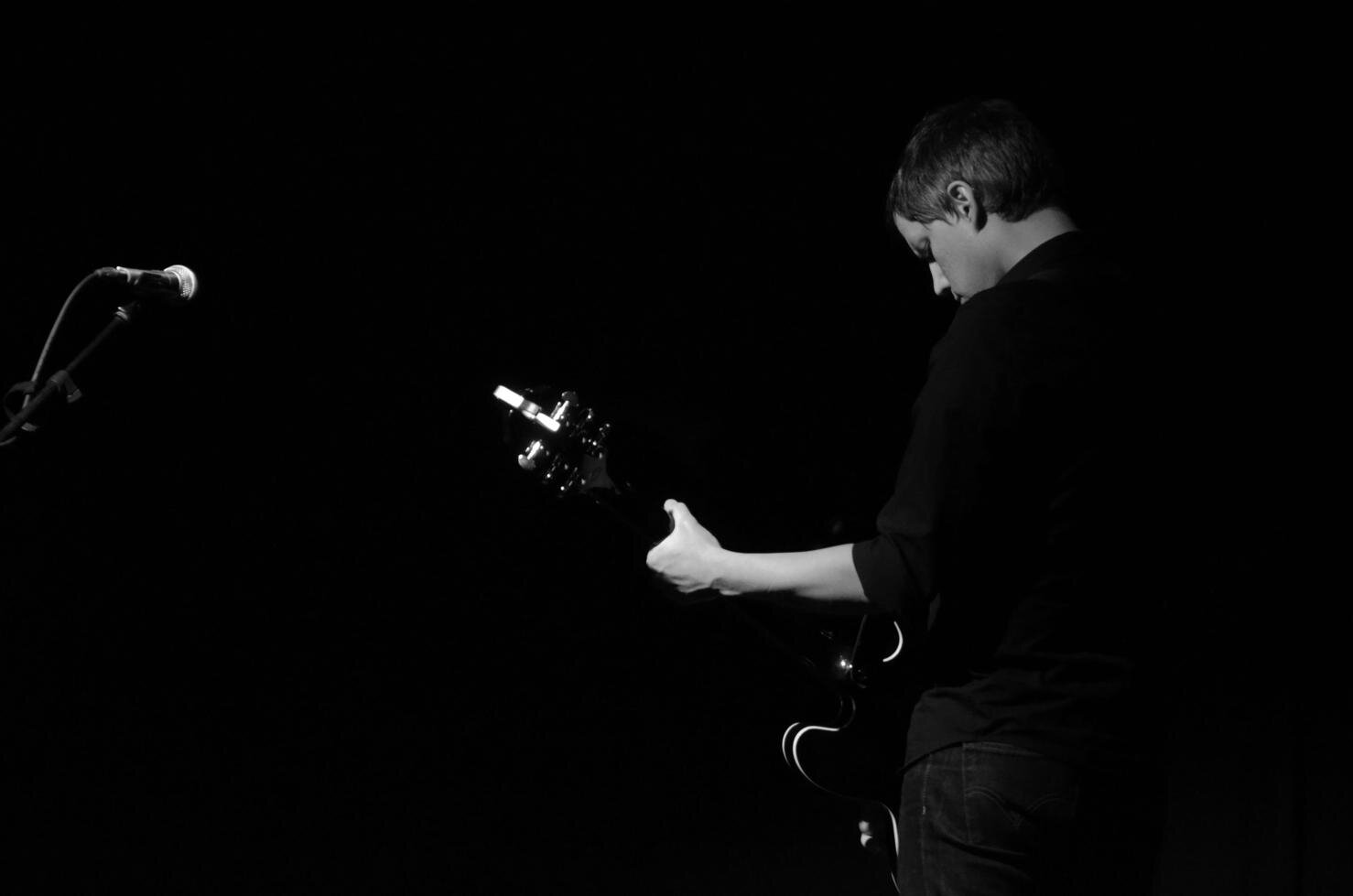 Black and white photo of Nathan Amundson aka Rivulets playing live.