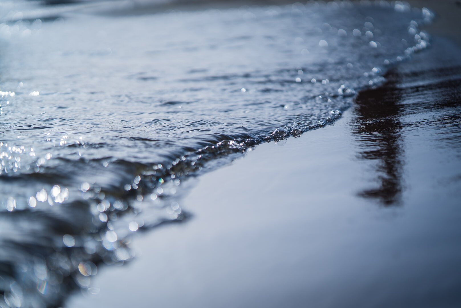 Water moving out of a wet Italian beach in the evening