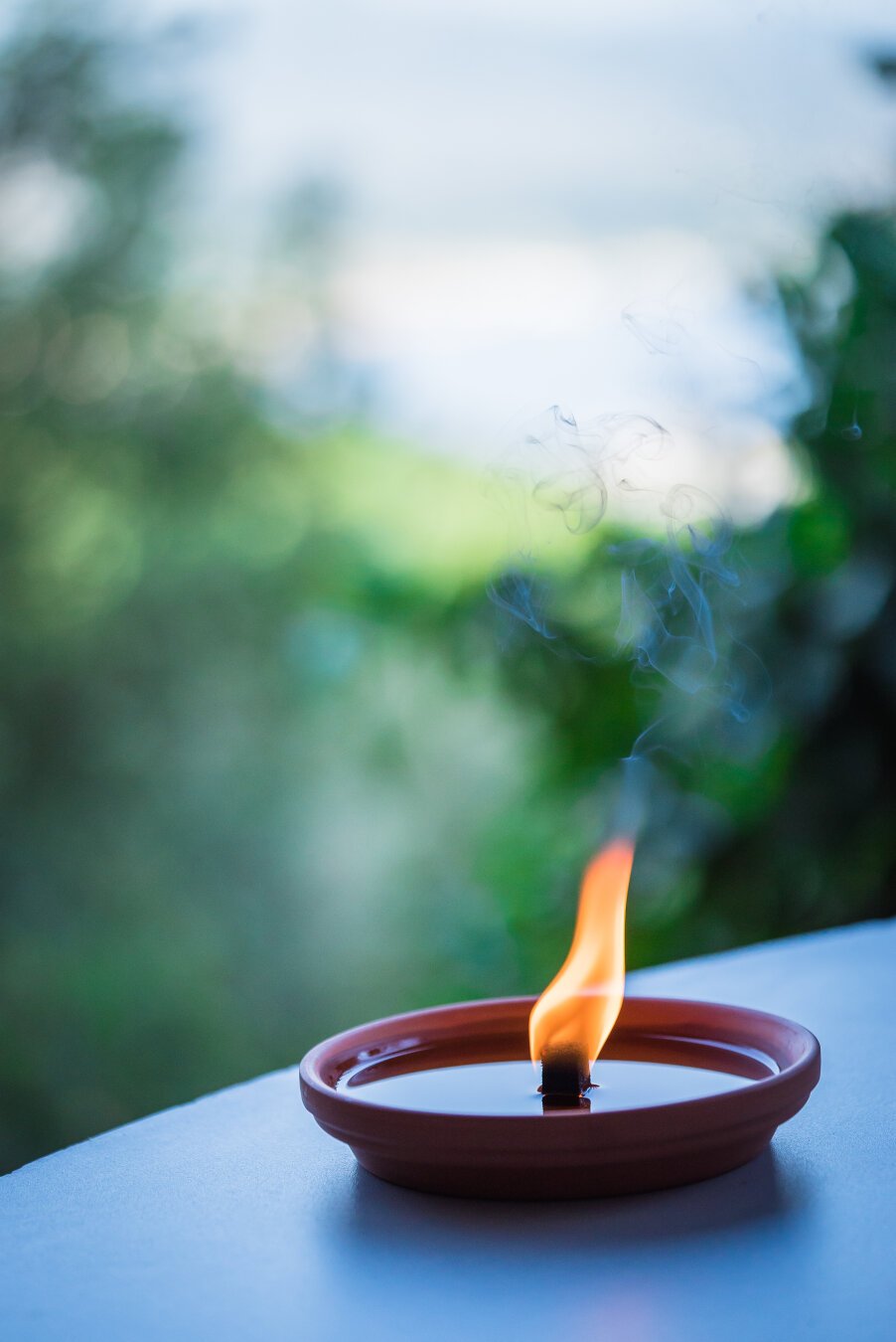 A citronella candle burning in the evening