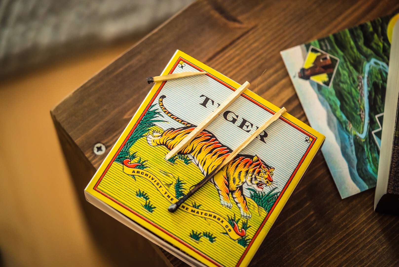 A fancy box of long matches depicting an illustration of a tiger. Two burned matches are lying on the box.