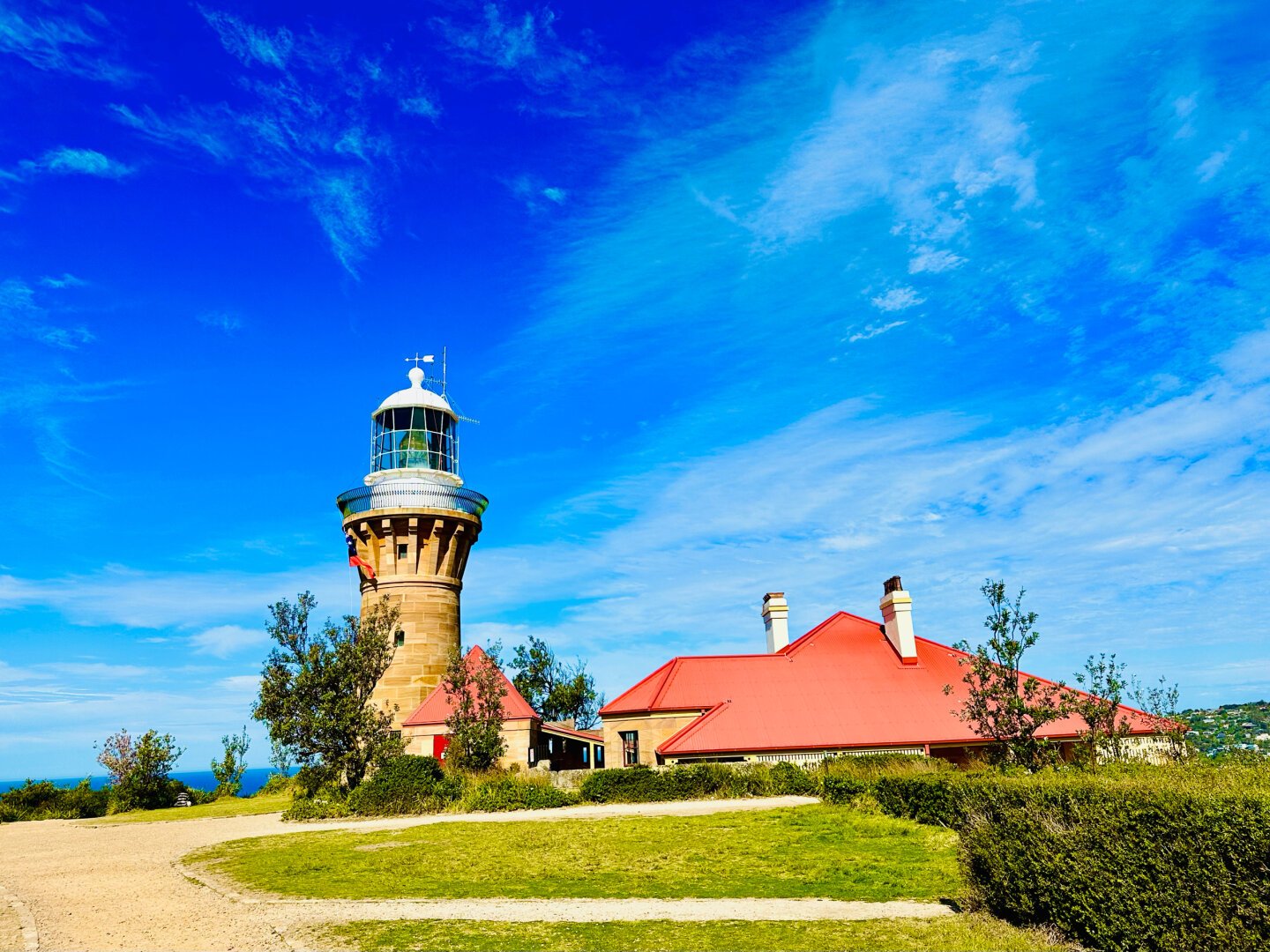 Historic Barrenjoey head lighthouse on a sunny day with blue skies.