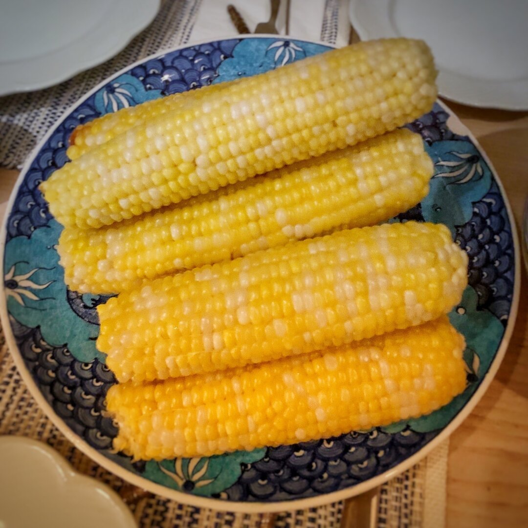Yellow corn cobs on a blue plate.