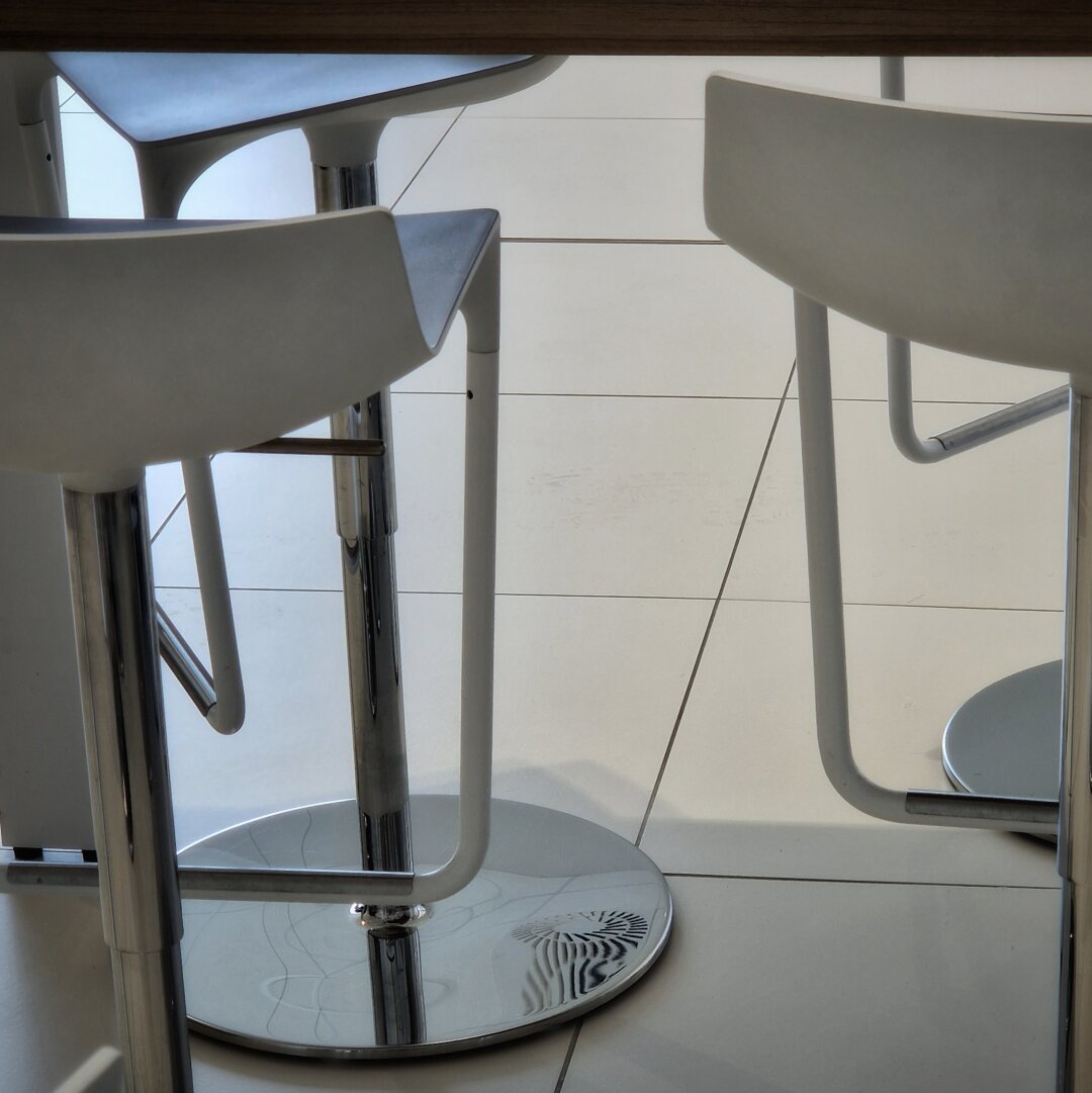 Seltsame Stühle unter einem Tisch