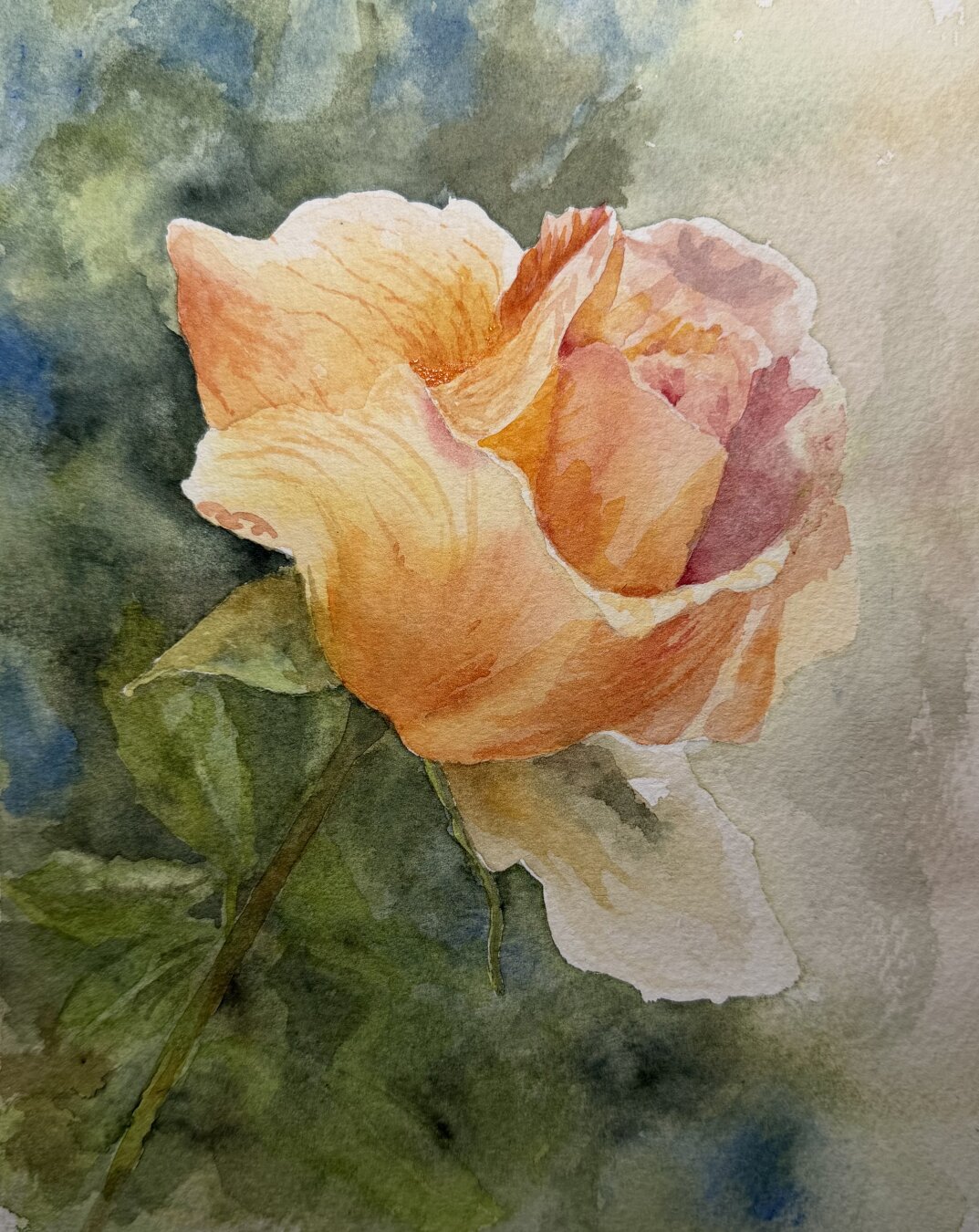A single rose glows in warm gold and coral tones against a moody blue-green backdrop, its petals catching soft light while a stem trails downward into shadow.